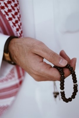 a man holding a amber rosary